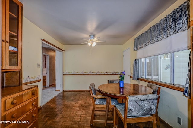 dining area featuring ceiling fan and baseboards