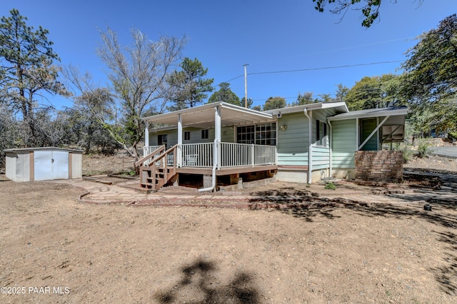 view of front of property with a storage shed, covered porch, and an outdoor structure