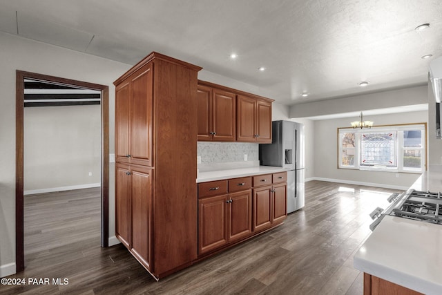 kitchen featuring an inviting chandelier, decorative backsplash, stainless steel appliances, and dark hardwood / wood-style floors