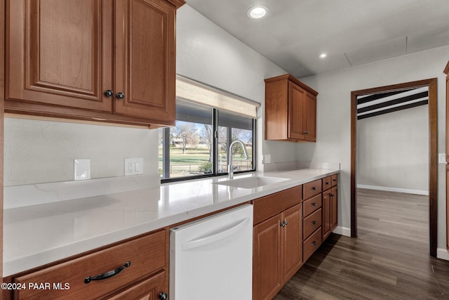 kitchen with dark hardwood / wood-style floors, light stone countertops, sink, and white dishwasher