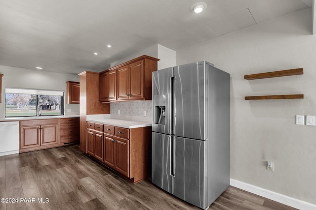 kitchen with sink, dishwasher, stainless steel refrigerator with ice dispenser, dark hardwood / wood-style flooring, and decorative backsplash