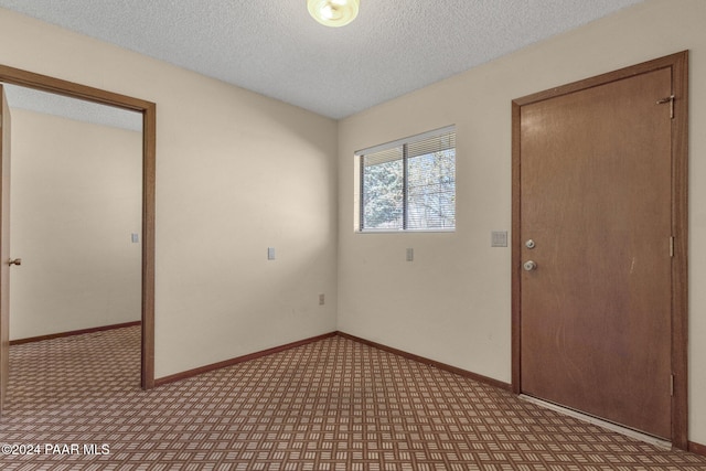 unfurnished room featuring a textured ceiling