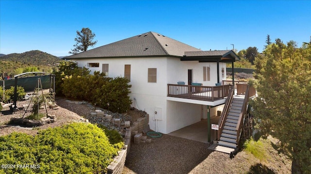 back of house featuring a patio area, stairs, stucco siding, and a deck