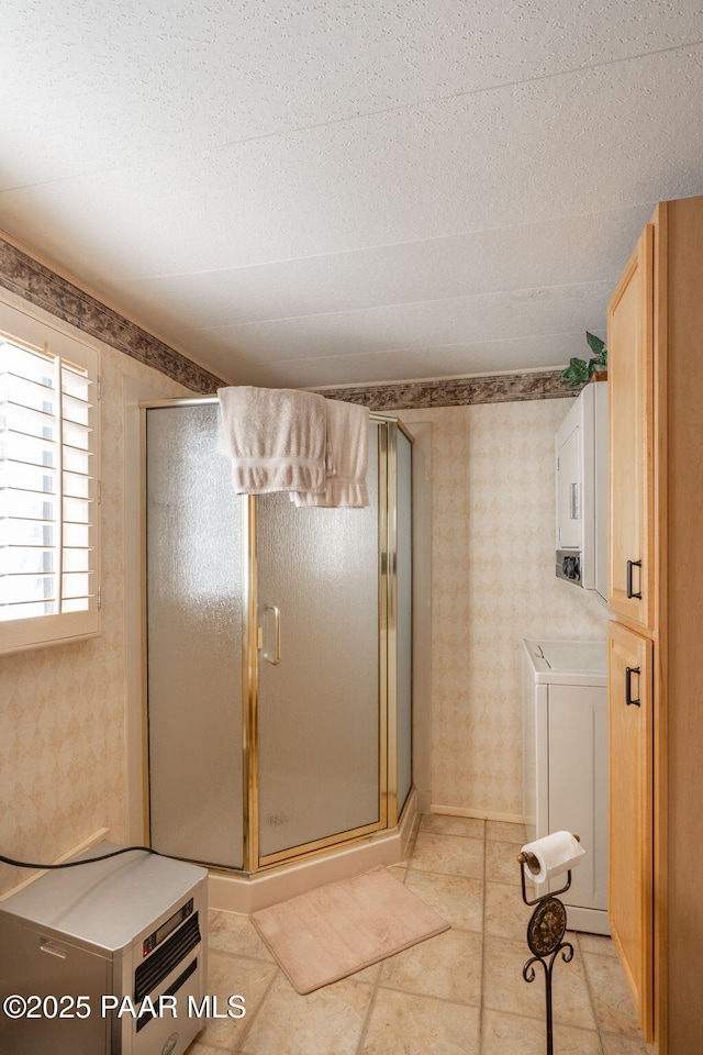 bathroom with walk in shower, washer / clothes dryer, and tile patterned floors