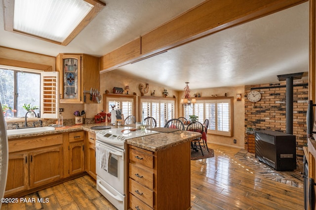 kitchen featuring dark hardwood / wood-style flooring, kitchen peninsula, white range with electric cooktop, and sink