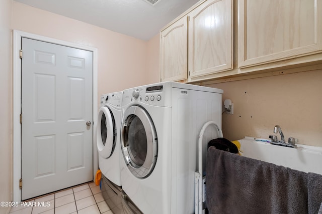 laundry room featuring a sink, light tile patterned flooring, washing machine and clothes dryer, and cabinet space