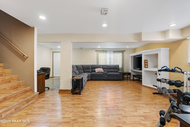 exercise area with light wood finished floors and recessed lighting