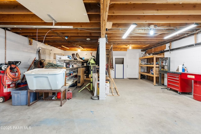 unfinished basement featuring refrigerator