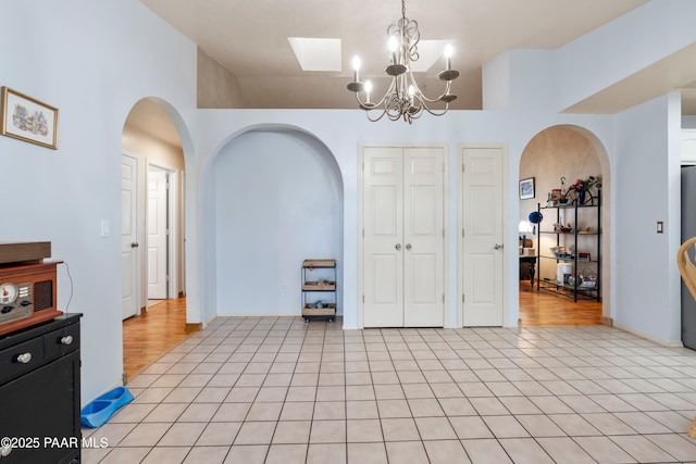 dining space featuring an inviting chandelier, arched walkways, and light tile patterned flooring