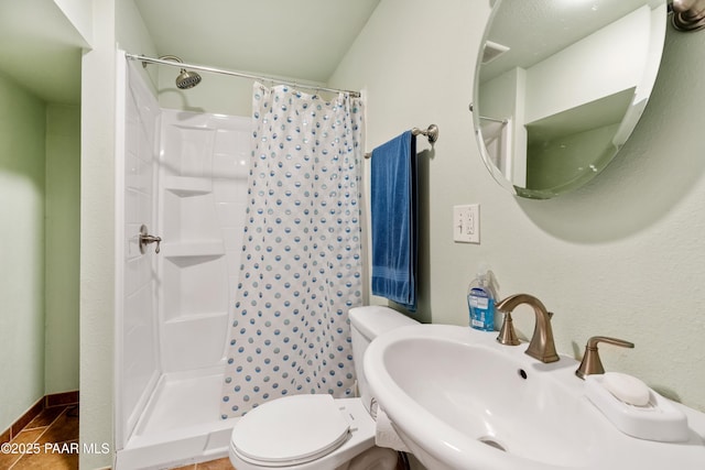 full bathroom featuring toilet, curtained shower, and a sink