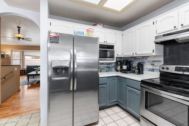 kitchen featuring light countertops, appliances with stainless steel finishes, white cabinets, and under cabinet range hood