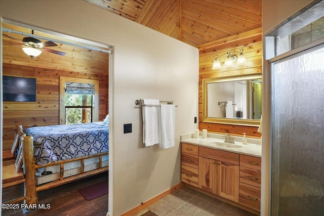 bathroom featuring ceiling fan, wooden walls, wood ceiling, and vanity