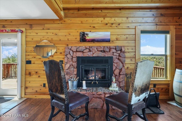 living area with a fireplace, a healthy amount of sunlight, and dark hardwood / wood-style floors