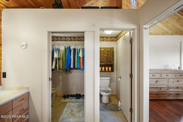 bathroom with wooden ceiling, vanity, and toilet