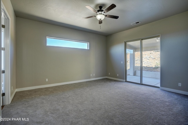 carpeted spare room featuring a textured ceiling and ceiling fan