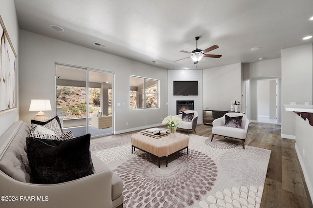 living room featuring a fireplace, ceiling fan, and hardwood / wood-style floors