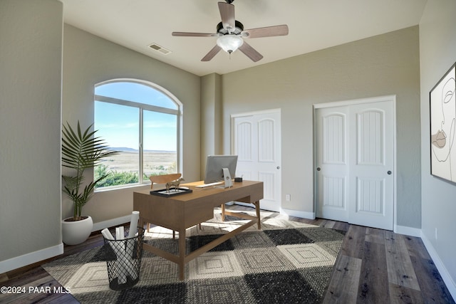 home office with ceiling fan and dark hardwood / wood-style flooring