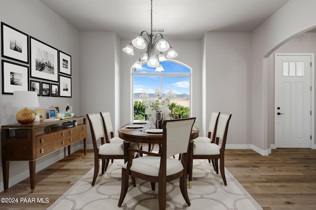 dining room with light hardwood / wood-style flooring and a notable chandelier