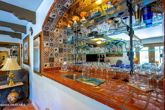 bar with tile countertops and sink