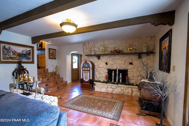 living room featuring tile patterned floors, beam ceiling, and a fireplace