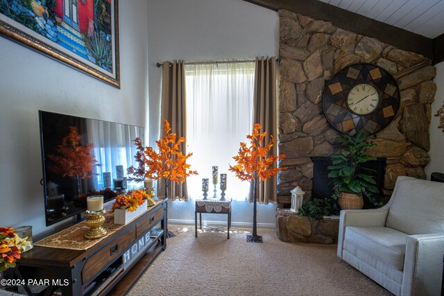 living area featuring carpet, a healthy amount of sunlight, and beam ceiling