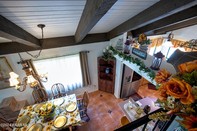 tiled dining space featuring beam ceiling, an inviting chandelier, plenty of natural light, and wood ceiling