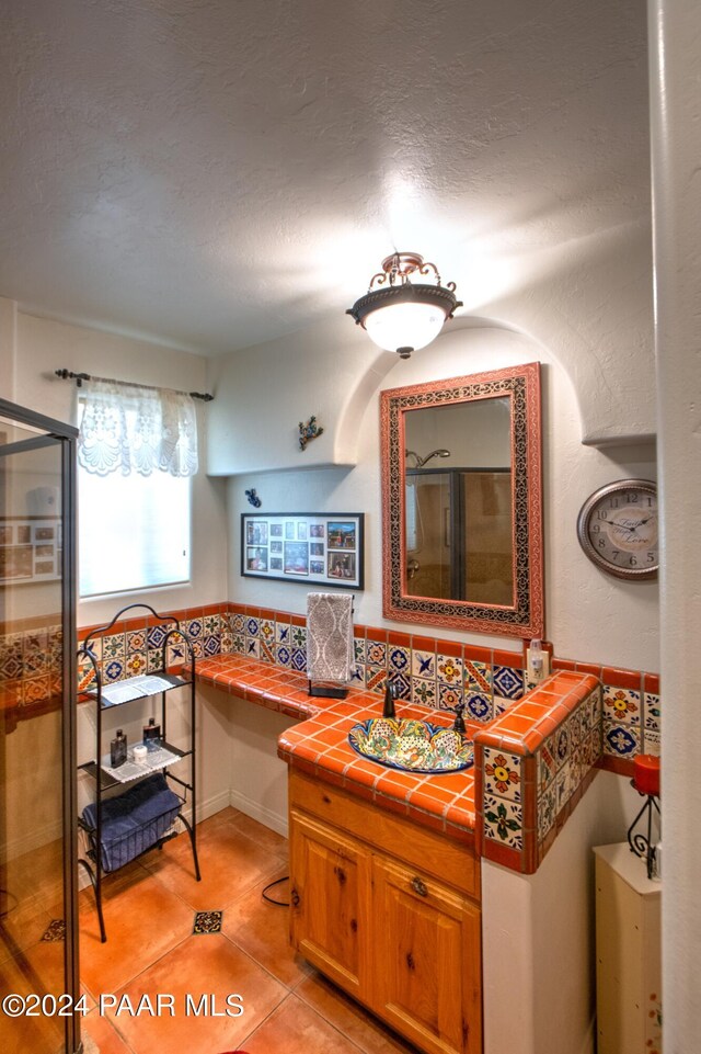 bathroom with breakfast area, walk in shower, vanity, a textured ceiling, and tile patterned flooring