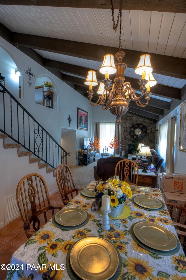 tiled dining area with lofted ceiling with beams and a chandelier