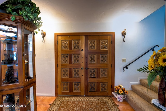 foyer featuring light tile patterned floors and french doors