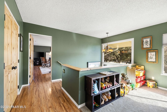 game room featuring wood-type flooring and a textured ceiling