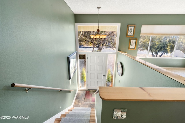 foyer with hardwood / wood-style flooring, a textured ceiling, and a chandelier