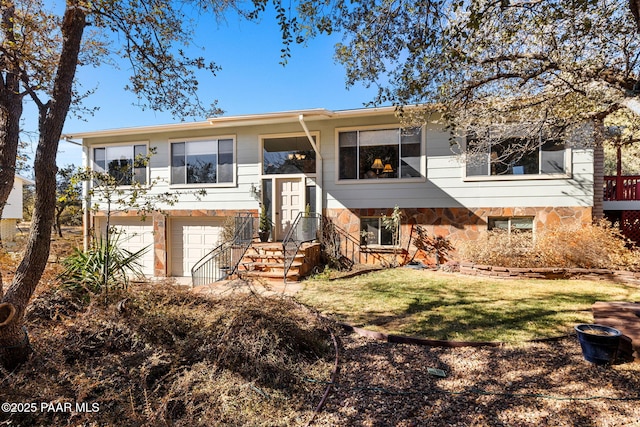 raised ranch with a garage and a front lawn