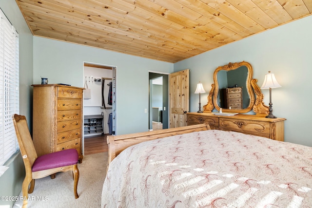 carpeted bedroom with wood ceiling, a walk in closet, and a closet