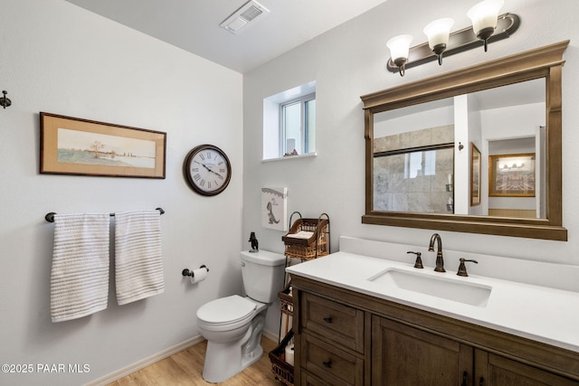 bathroom featuring walk in shower, vanity, toilet, and hardwood / wood-style floors