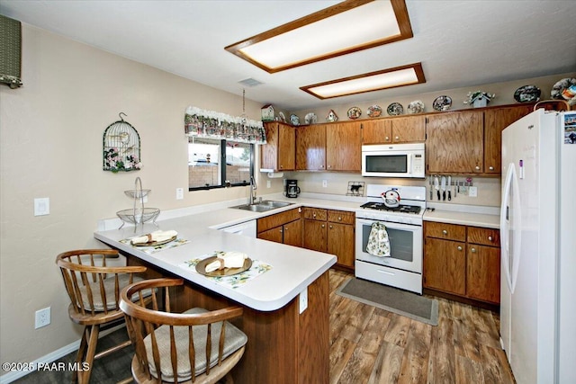 4761 N Tonto Way, Prescott Valley, AZ 86314 - kitchen featuring white appliances, brown cabinetry, a peninsula, light wood-type flooring, and light countertops