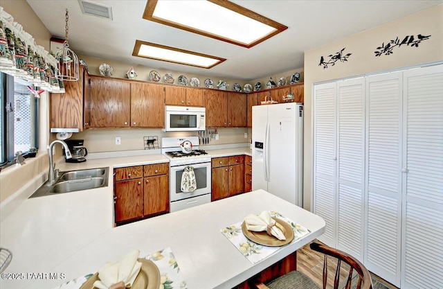 4761 N Tonto Way, Prescott Valley, AZ 86314 - kitchen with white appliances, brown cabinets, a peninsula, and light countertops