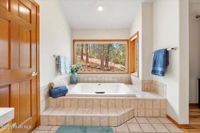 bathroom featuring tile patterned floors and a bath