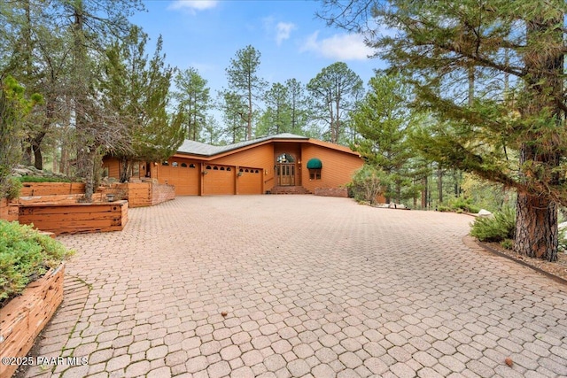 view of front of home with decorative driveway and an attached garage