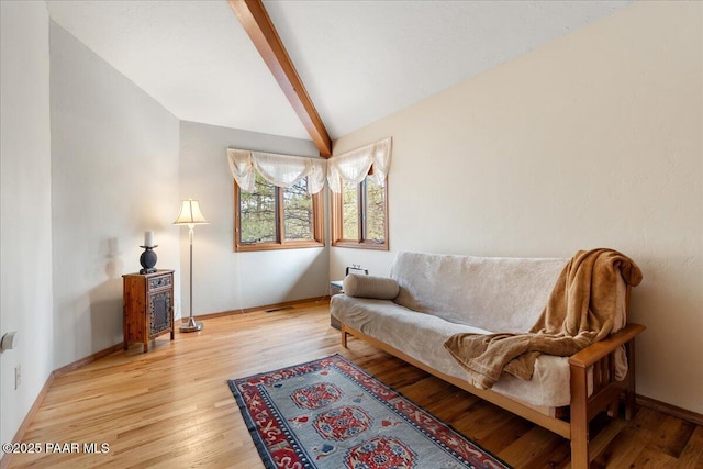 sitting room featuring lofted ceiling with beams, light wood-style flooring, and baseboards