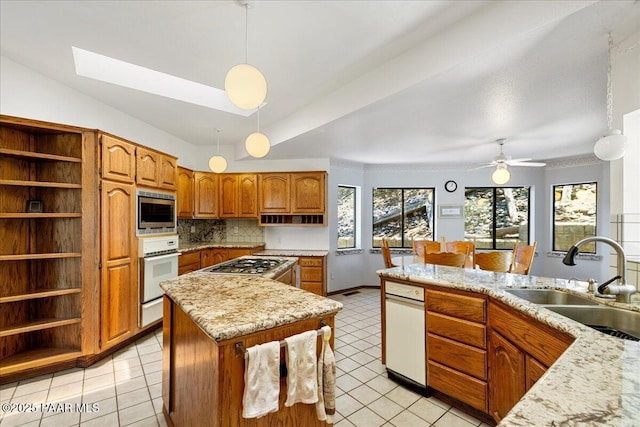 110 High Chaparral Loop, Prescott, AZ 86303 - kitchen featuring a sink, appliances with stainless steel finishes, brown cabinetry, a center island, and open shelves