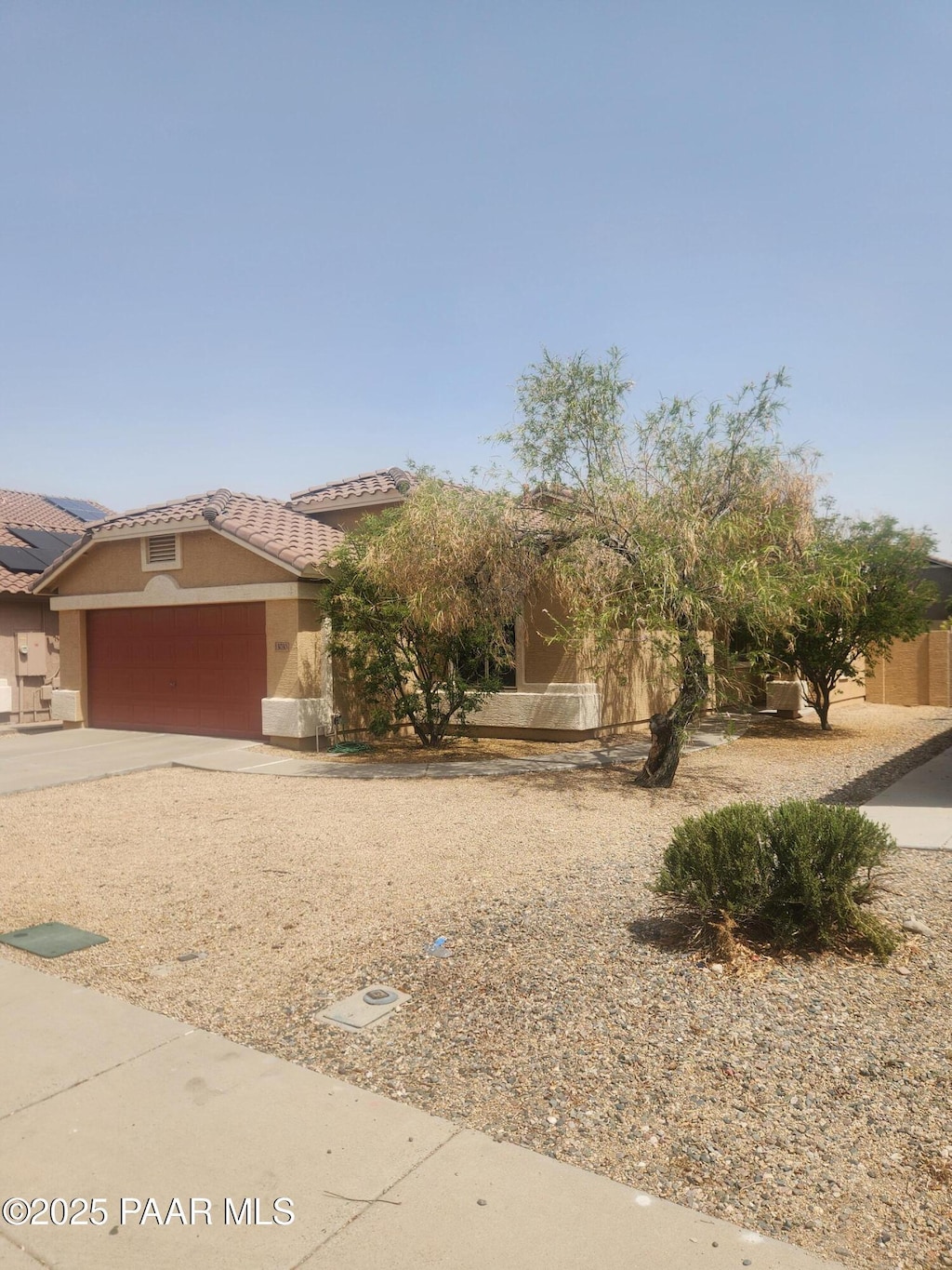 13030 W Columbine Dr, El Mirage, AZ 85335 - view of front of home with a garage, a tiled roof, stucco siding, and concrete driveway