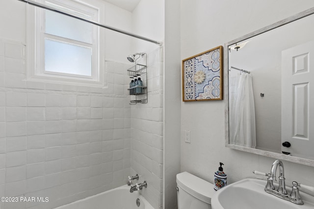 full bathroom featuring sink, shower / bathtub combination with curtain, and toilet