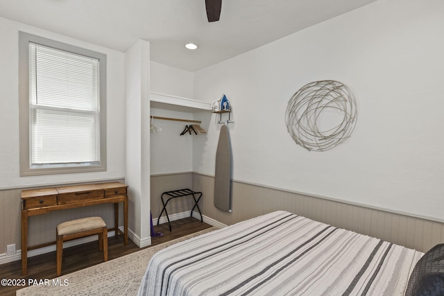 bedroom featuring a wainscoted wall, a ceiling fan, and wood finished floors