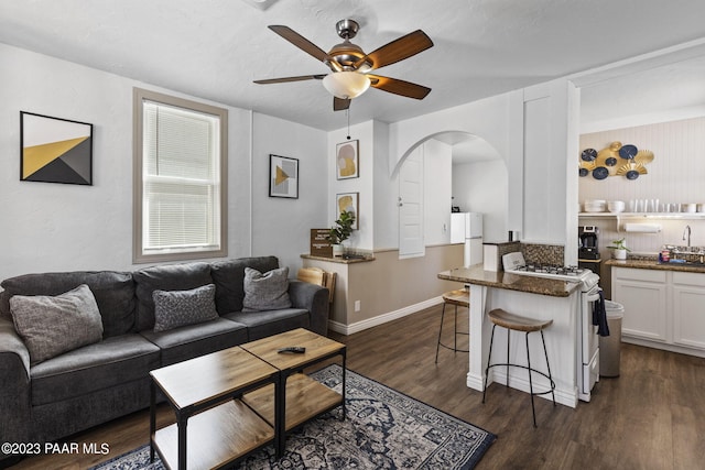 living room with dark hardwood / wood-style floors and ceiling fan