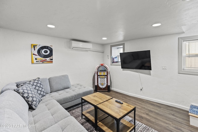 living area featuring a wall mounted air conditioner, baseboards, wood finished floors, and recessed lighting