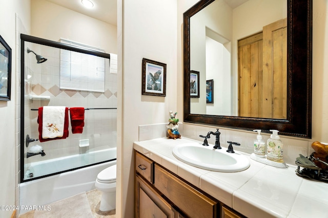 full bathroom with vanity, backsplash, toilet, and bath / shower combo with glass door