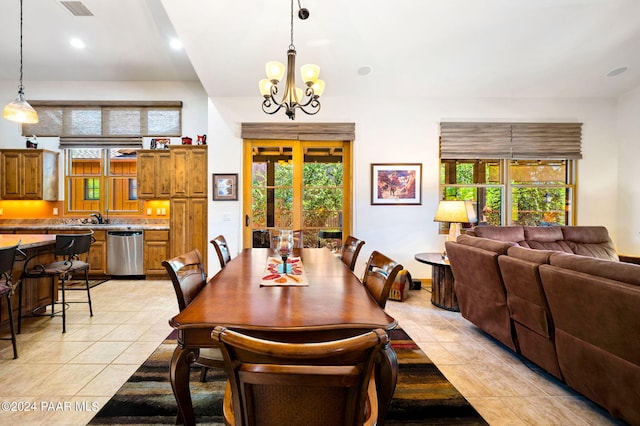 tiled dining space with a wealth of natural light, sink, a chandelier, and french doors