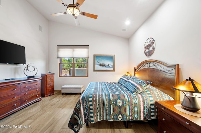 bedroom with ceiling fan, vaulted ceiling, and light wood-type flooring