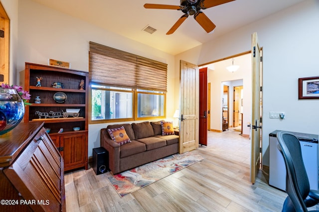 living room with light hardwood / wood-style flooring and ceiling fan