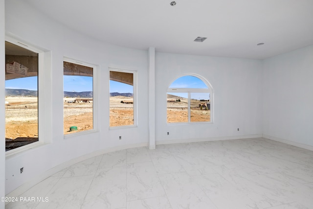 unfurnished room featuring a mountain view